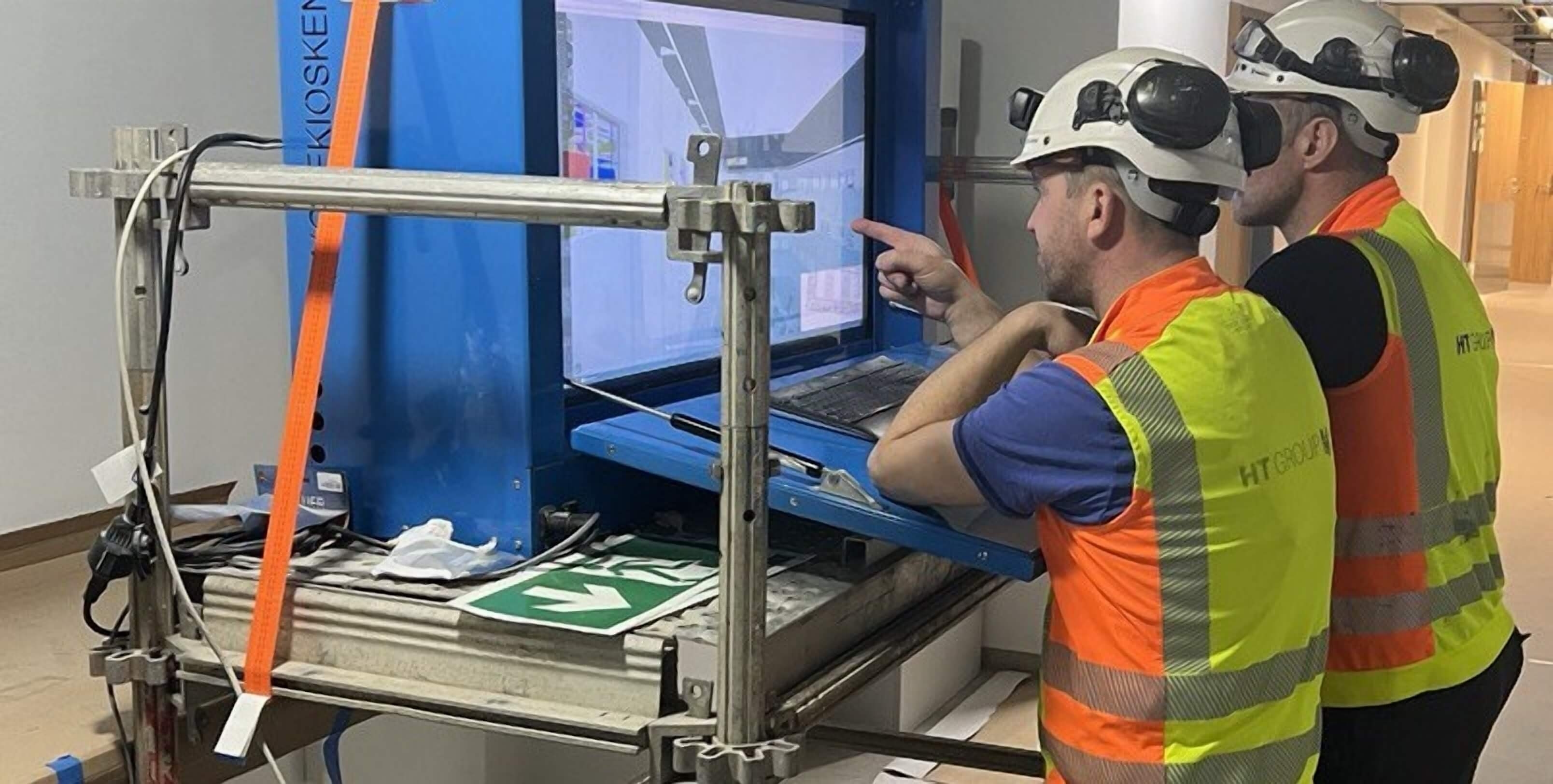 Two engineers looking at a blueprint on a screen
